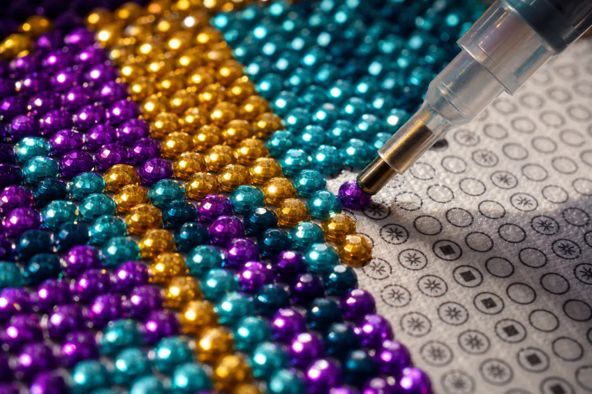 Фасетирани камъчета върху платно на диамантен гоблен отблизо